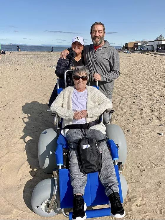 Family on the beach with beach wheelchair