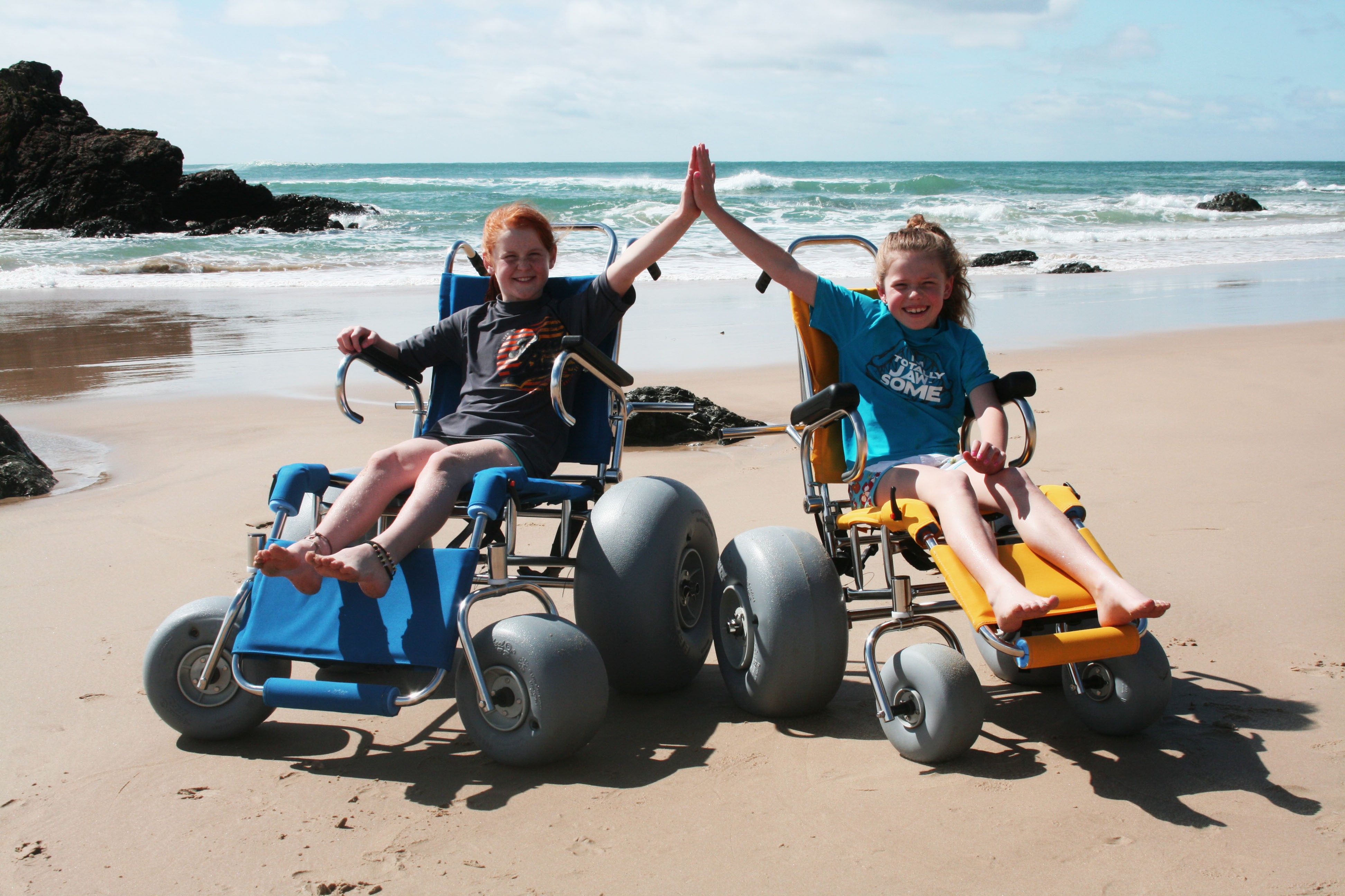 children in beach wheelchairs